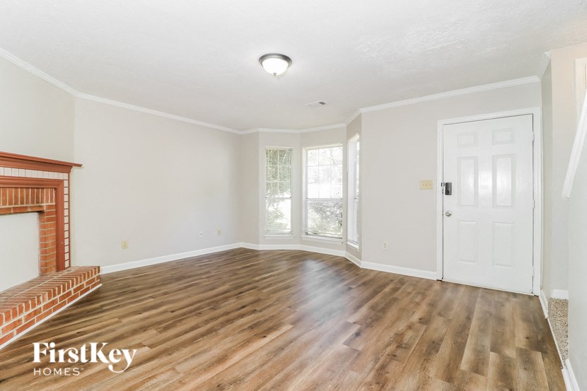 an empty living room with a fireplace and a door