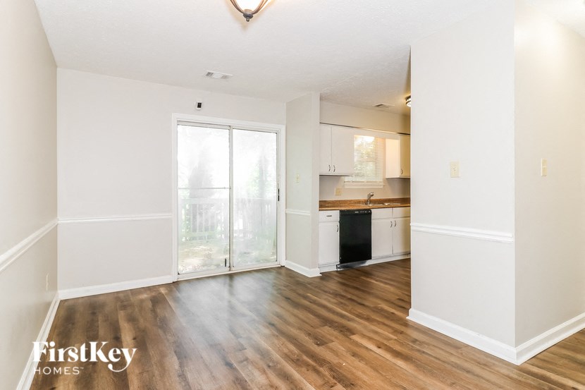 an empty living room and kitchen with a sliding glass door