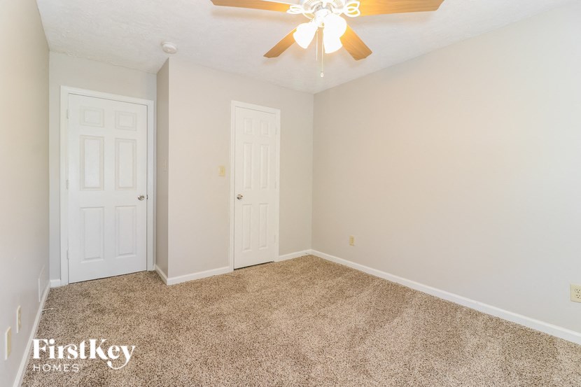 a bedroom with two doors and a ceiling fan
