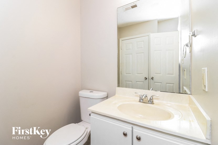 a bathroom with a sink toilet and a mirror