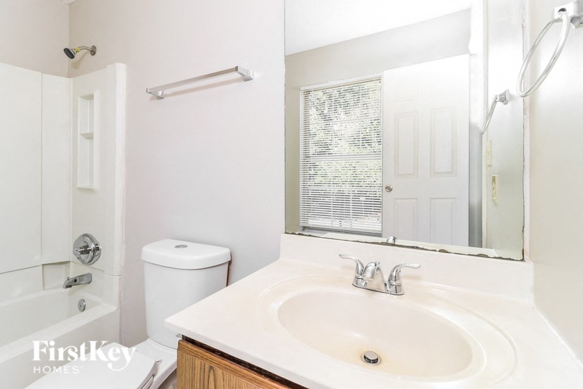 a white bathroom with a sink and a mirror