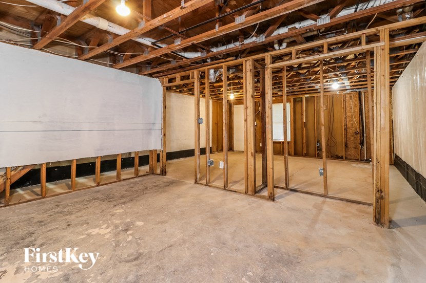 a unfinished basement with wood framing and a white wall