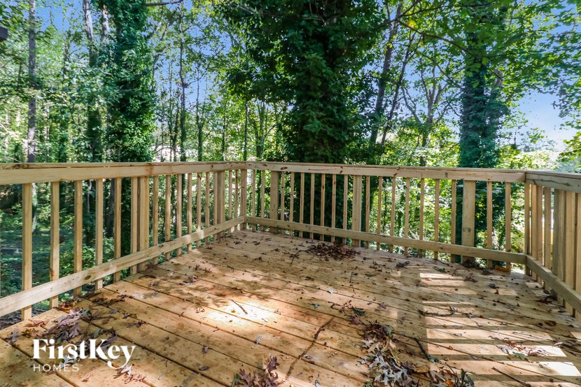 a wooden deck with trees in the background