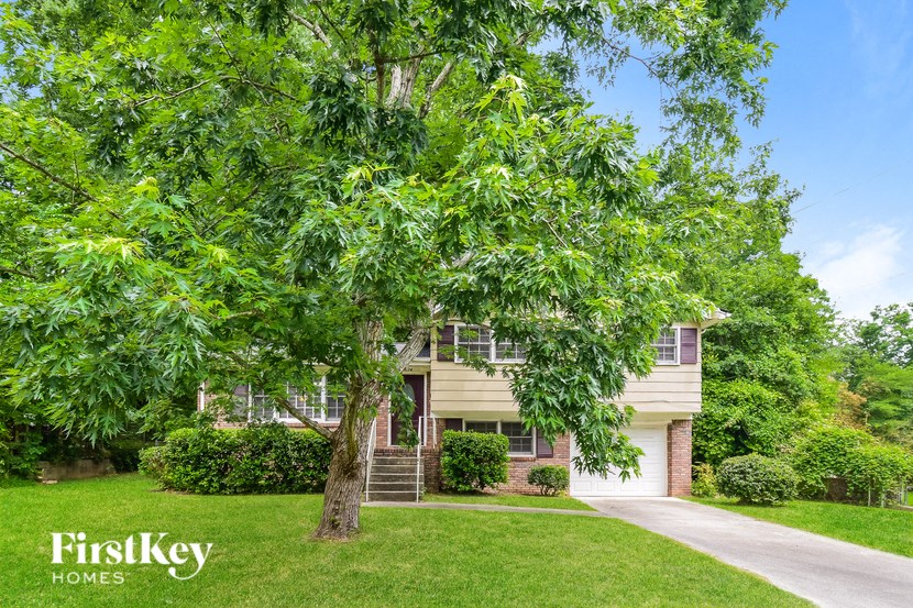 A tree in front of a house with the words "FirstKey Homes" on the bottom left.