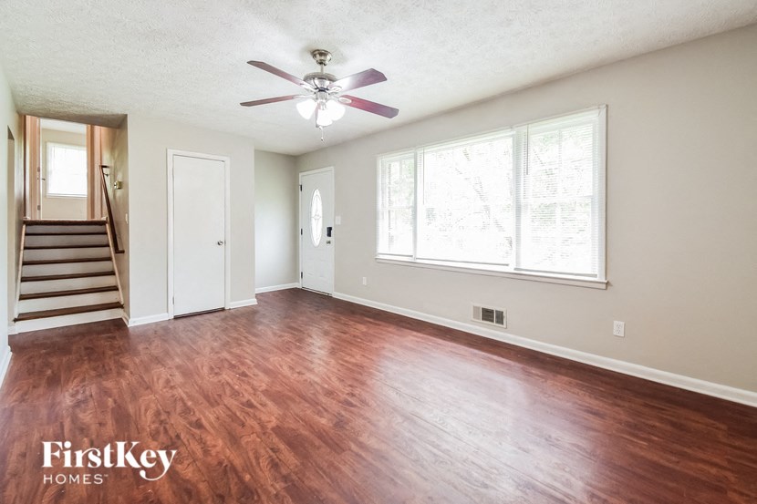 A room with a wooden floor and a ceiling fan.
