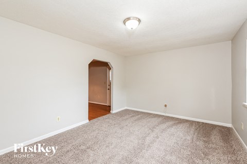 A room with a carpeted floor and a brown door.