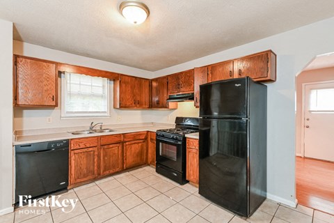 A kitchen with wooden cabinets and black appliances.