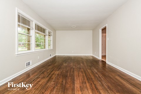 a spacious living room with hardwood floors and a large window