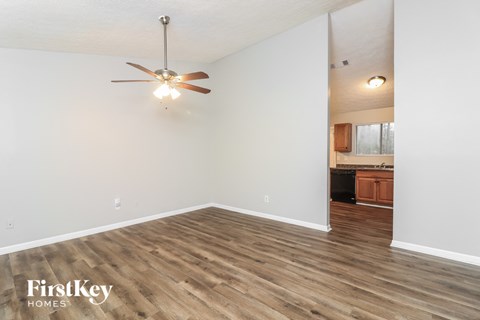 A room with a ceiling fan and wooden flooring.