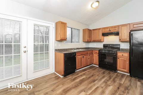 A kitchen with wooden cabinets and black appliances.