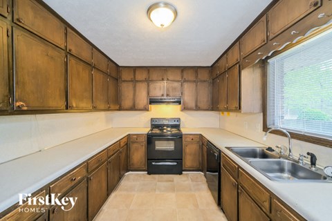 a kitchen with wooden cabinets and a sink and a stove
