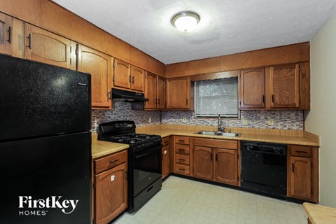 A kitchen with wooden cabinets and black appliances.