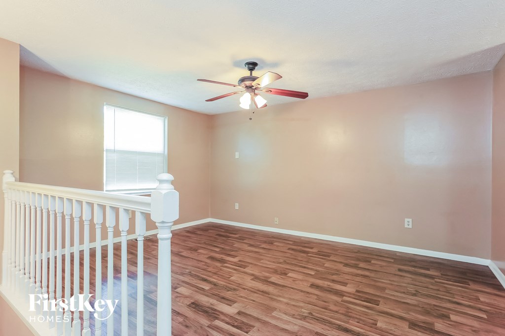 a living room with a staircase and a ceiling fan