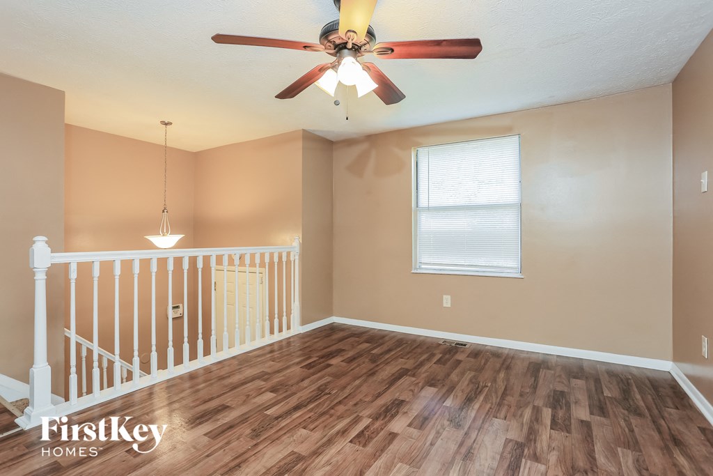 the living room of an empty house with a ceiling fan
