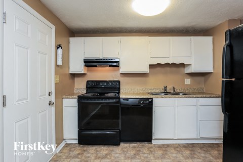 a kitchen with black appliances and white cabinets