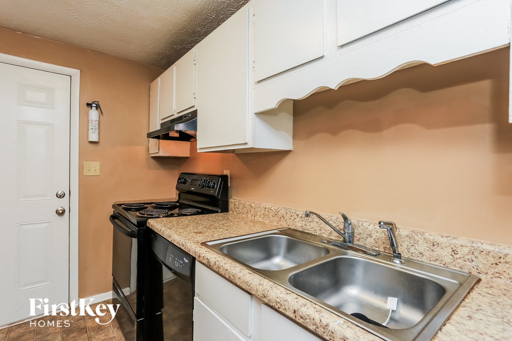 a kitchen with a sink and a stove and a microwave