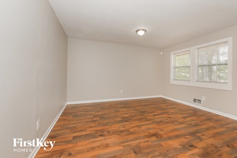 the living room of an empty house with wood flooring
