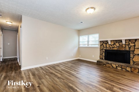 A living room with a fireplace and wood flooring.