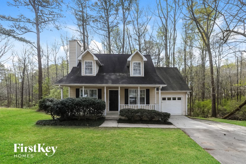 a white house with a lawn and trees