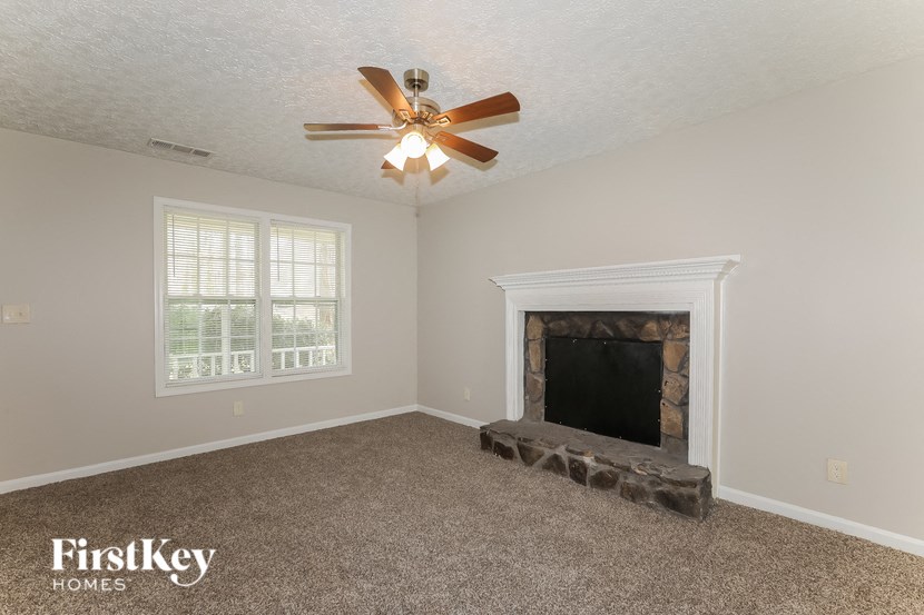a living room with a fireplace and a ceiling fan