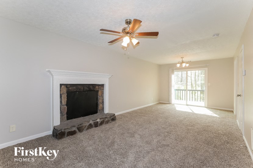 a living room with a fireplace and a ceiling fan