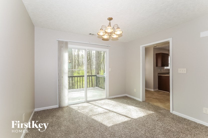 a living room with a patio door and a chandelier
