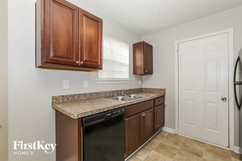 a kitchen with brown cabinets and a sink and a refrigerator