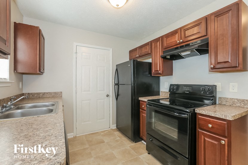a kitchen with black appliances and wooden cabinets and a black refrigerator