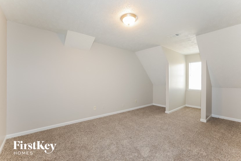 a room with carpet and white walls and a window