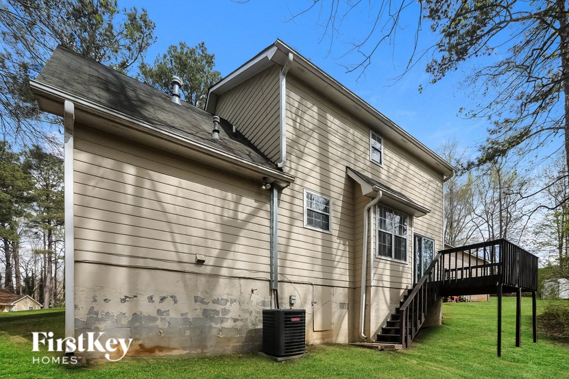 the side of a house with a deck and a staircase