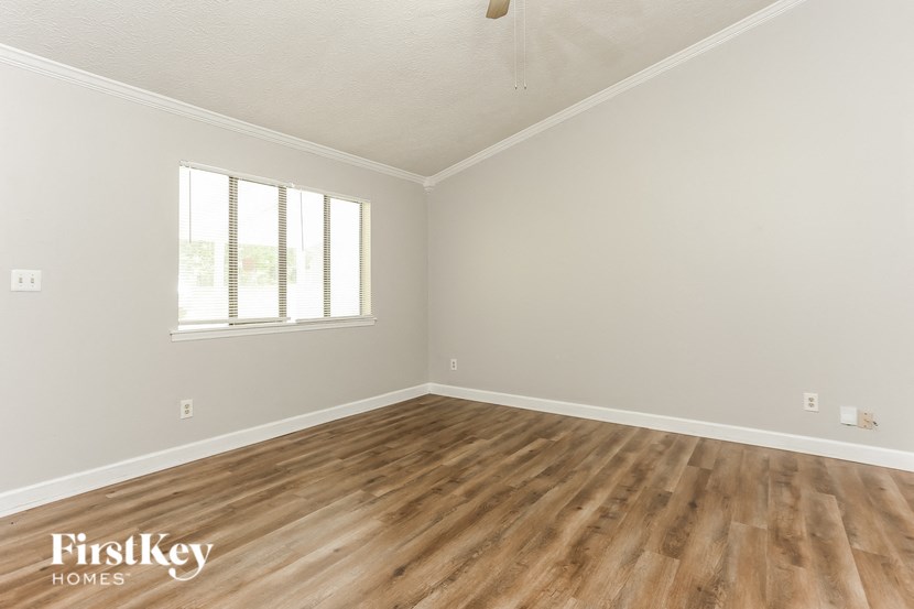 the living room of an empty house with wooden floors and a window