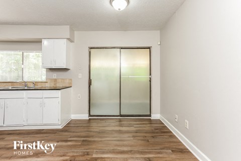 a kitchen with white cabinets and a stainless steel refrigerator