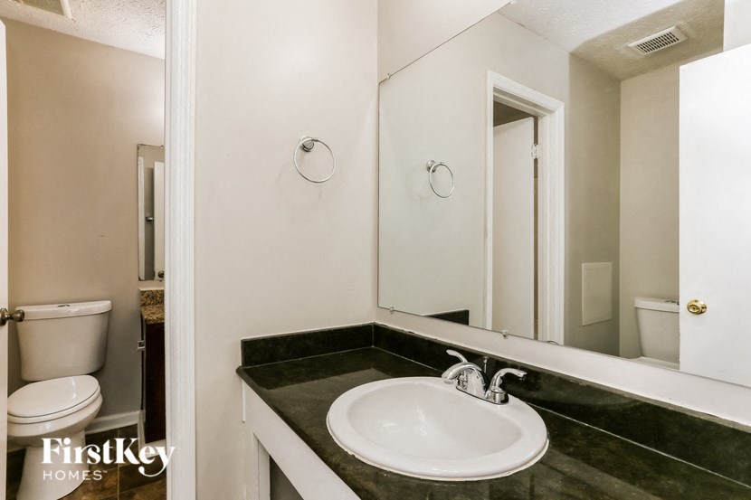 a bathroom with a sink and a mirror and a toilet