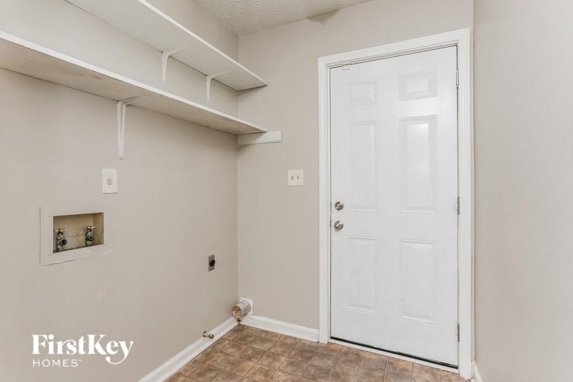 a room with a white door and a closet and a shelf on the wall