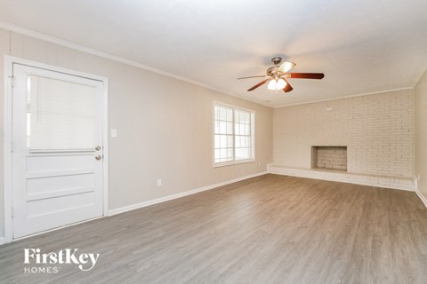 the living room of an empty house with a ceiling fan