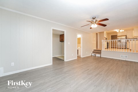 a living room with a ceiling fan and a white wall