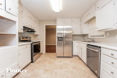 a white kitchen with stainless steel appliances and white cabinets