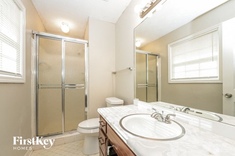 a bathroom with a sink and a shower and a toilet