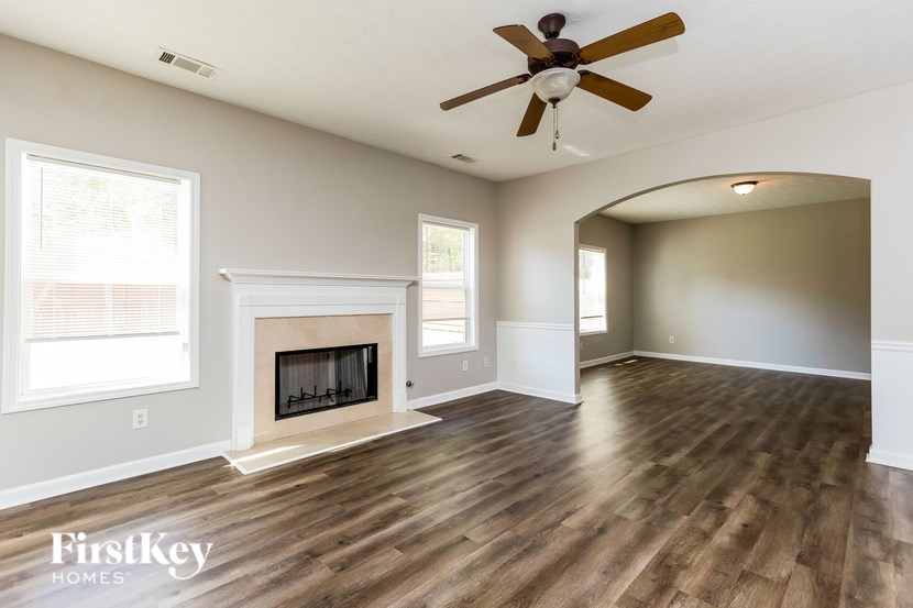 A spacious room with a fireplace and a ceiling fan.