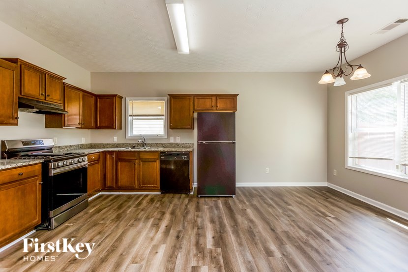 A kitchen with wooden floors and a refrigerator.