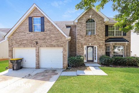 a home with a white garage door and a brick house