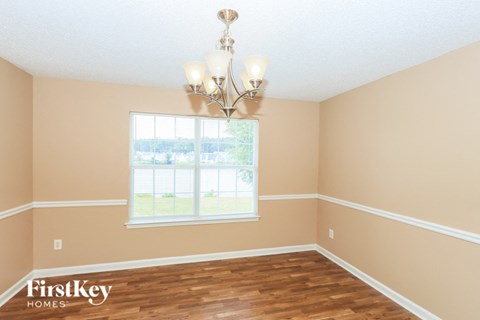 a dining room with a window and a chandelier