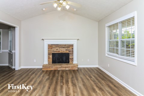 A room with a fireplace and wooden floors.