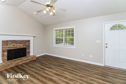 A room with a fireplace and a ceiling fan.