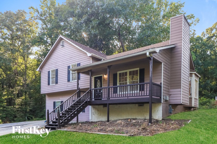 A house with a porch and a staircase leading to the entrance.