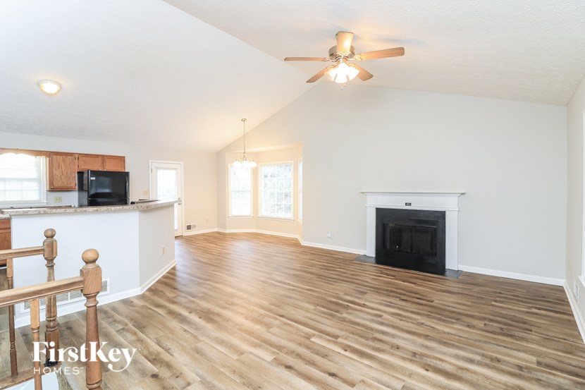 A spacious living room with wood flooring and a fireplace.