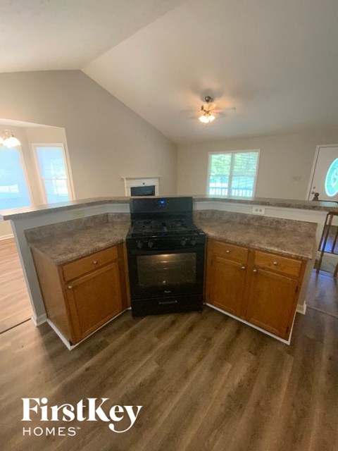 A kitchen with a black oven and wooden cabinets.