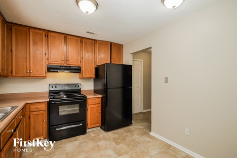 A kitchen with wooden cabinets and black appliances.