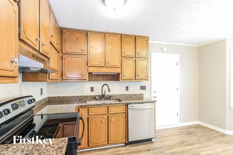 a kitchen with wood cabinets and granite counter tops and a stove and sink