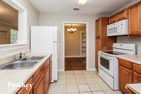 a kitchen with white appliances and wooden cabinets